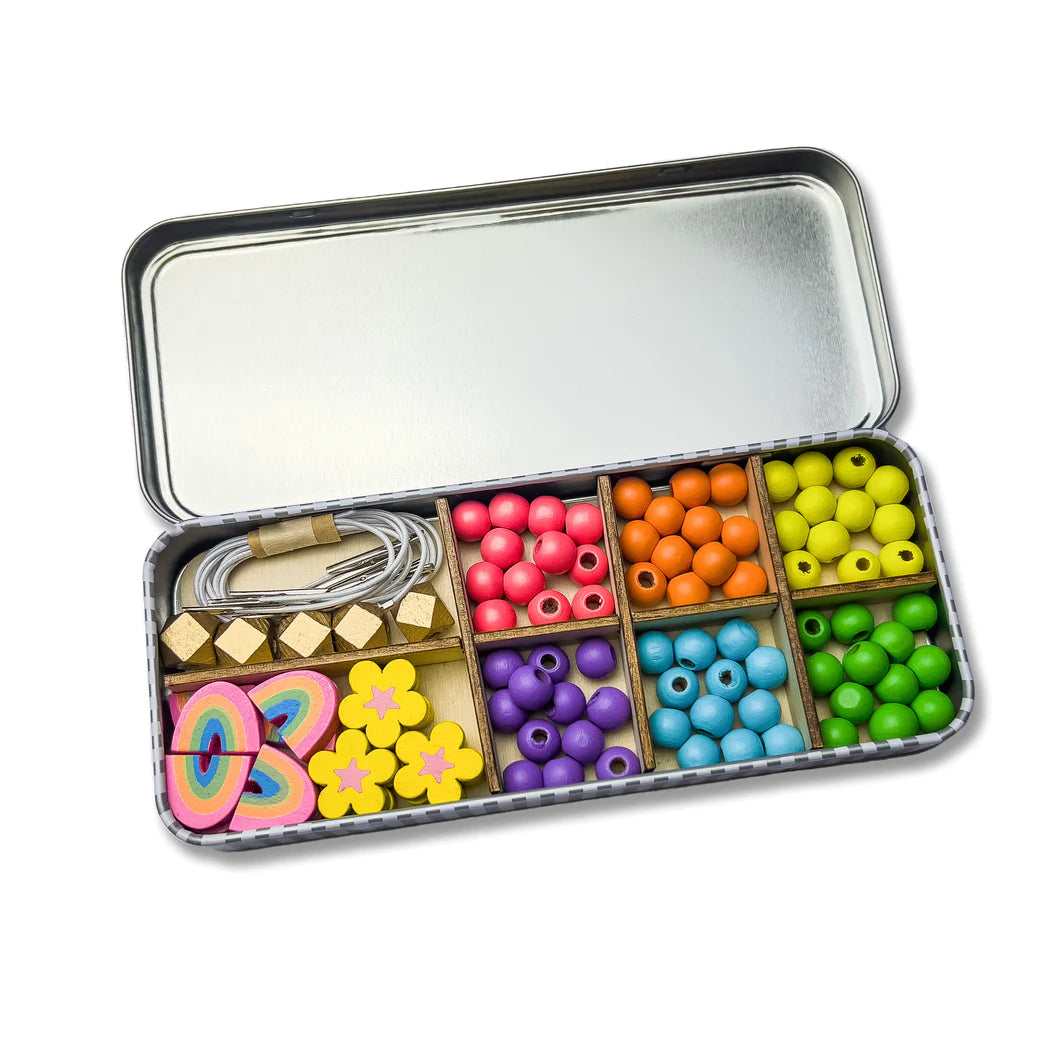 A tin containing a wooden rainbow bead bracelet making set