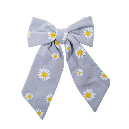 A pretty blue children’s hair bow with a daisy print on a clip 