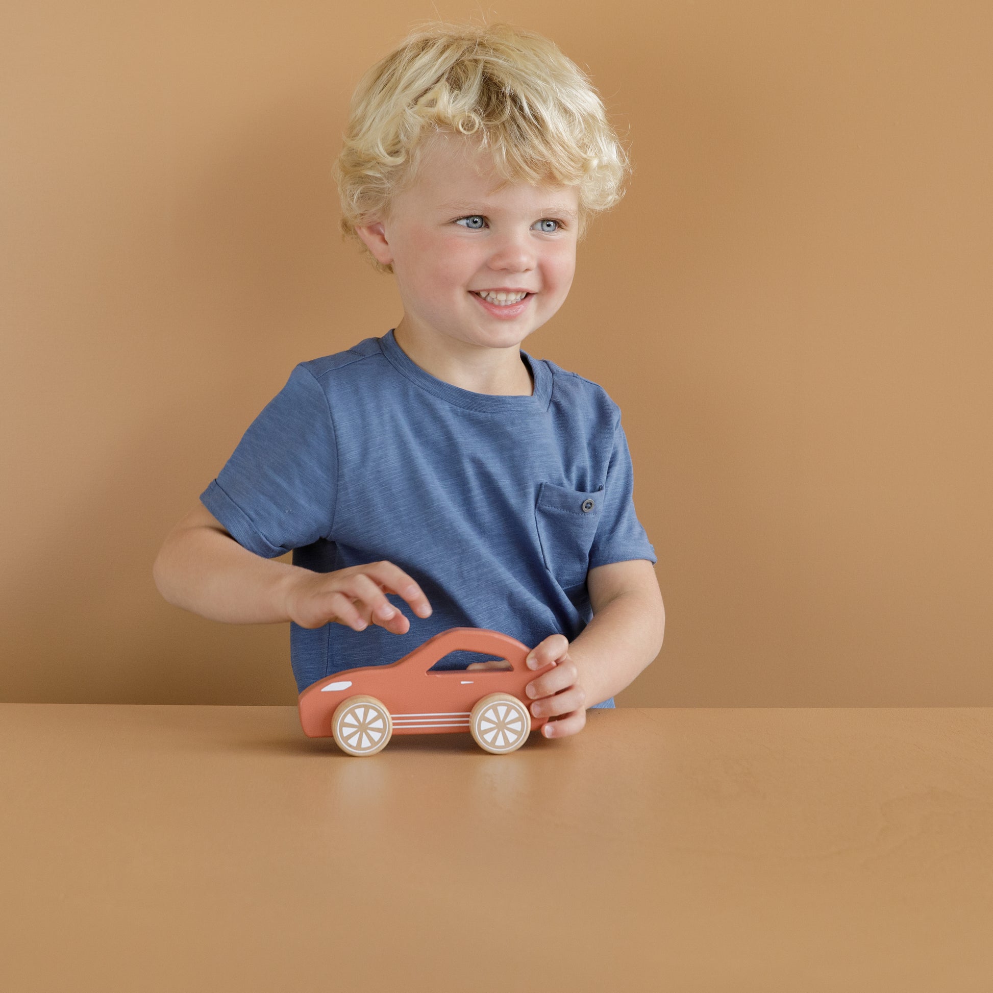 Child playing with Little Dutch wooden red sports car