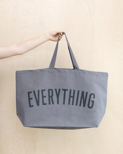 large grey tote bag screenprinted with the word everything in charcoal grey