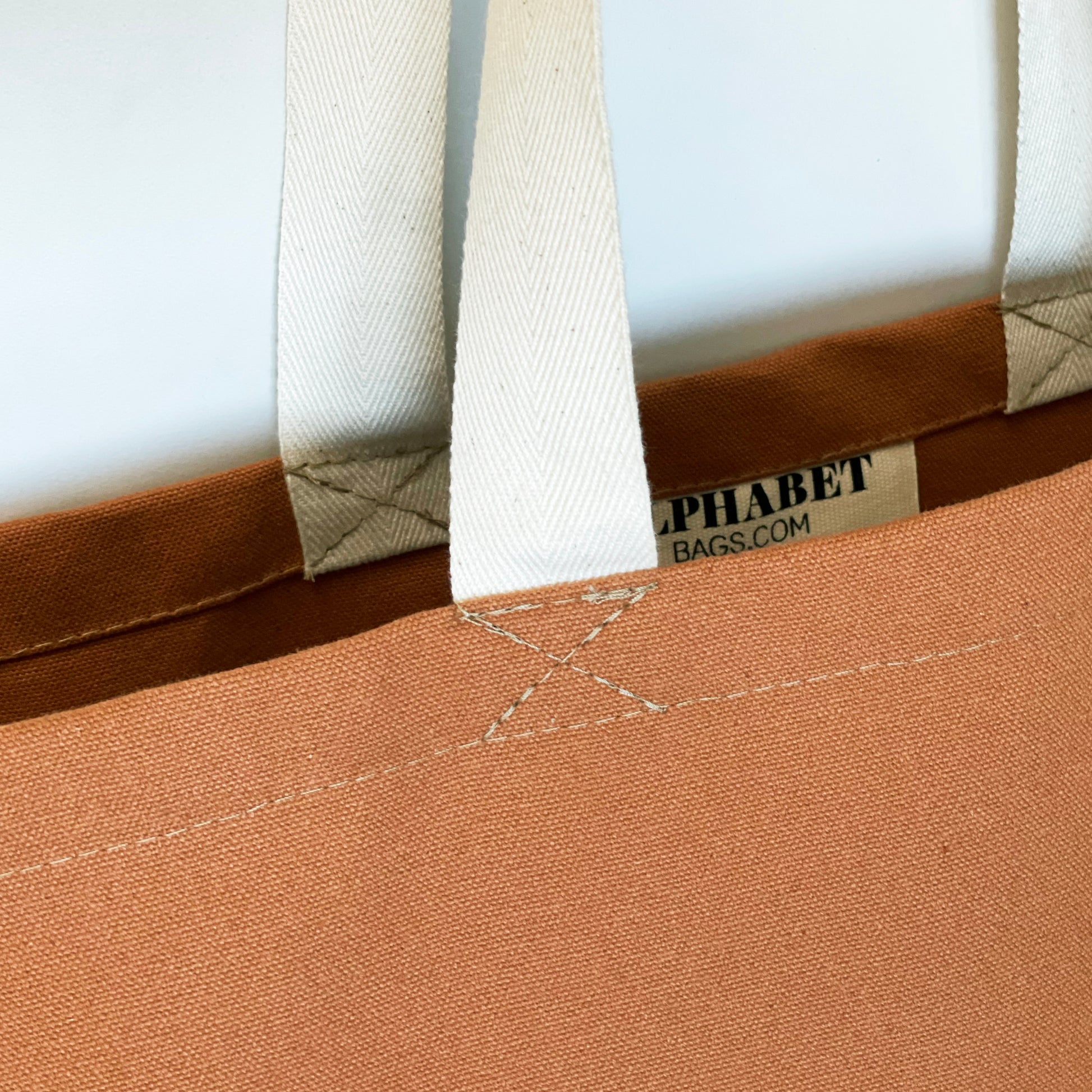 close of of the handles of everything bag in tan