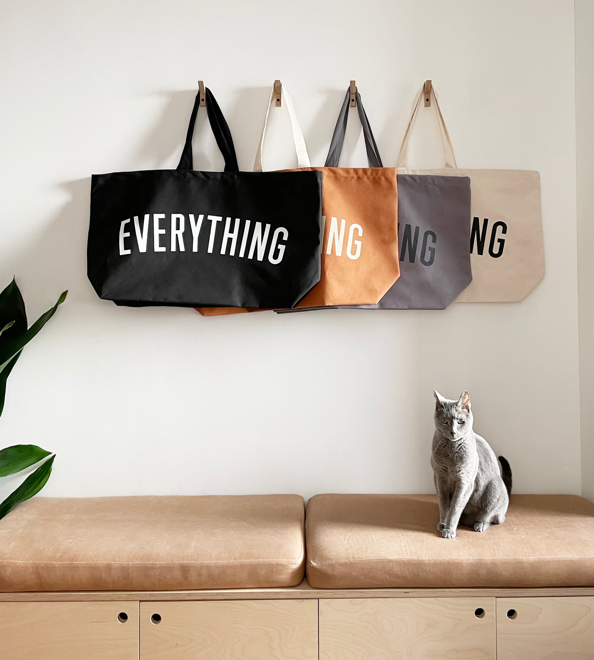 black, tan, grey and natural tote bags screenprinted with the word everything